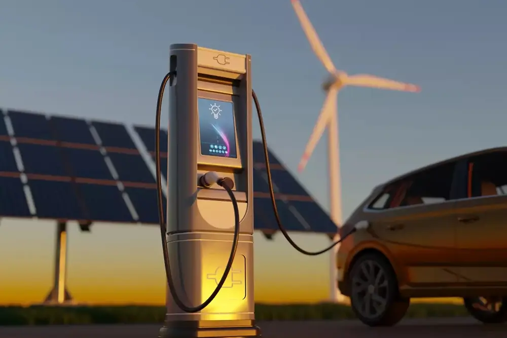 背景にソーラーパネルと風力タービンが見える電気自動車充電ステーション。