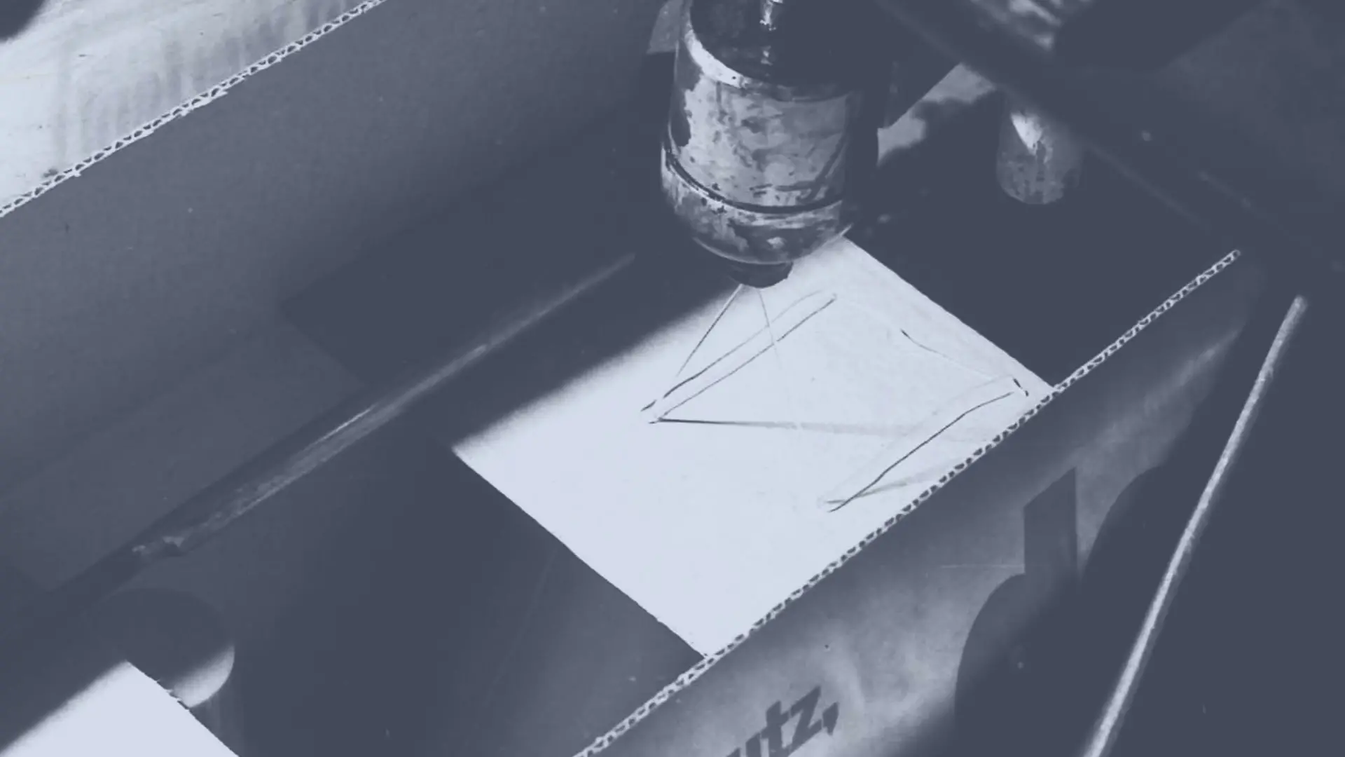 テクノメルトのホットメルト接着剤をスプレーして段ボール箱を封かんする様子。